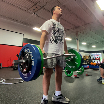 An athlete with Down syndrome performing trap bar deadlifts.